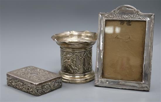 A late Victorian repousse silver bottle stand, a late Victorian silver box by William Comyns and a photograph frame.